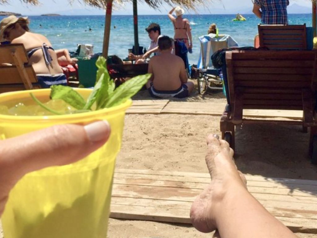 barefoot on the beach with a cocktail