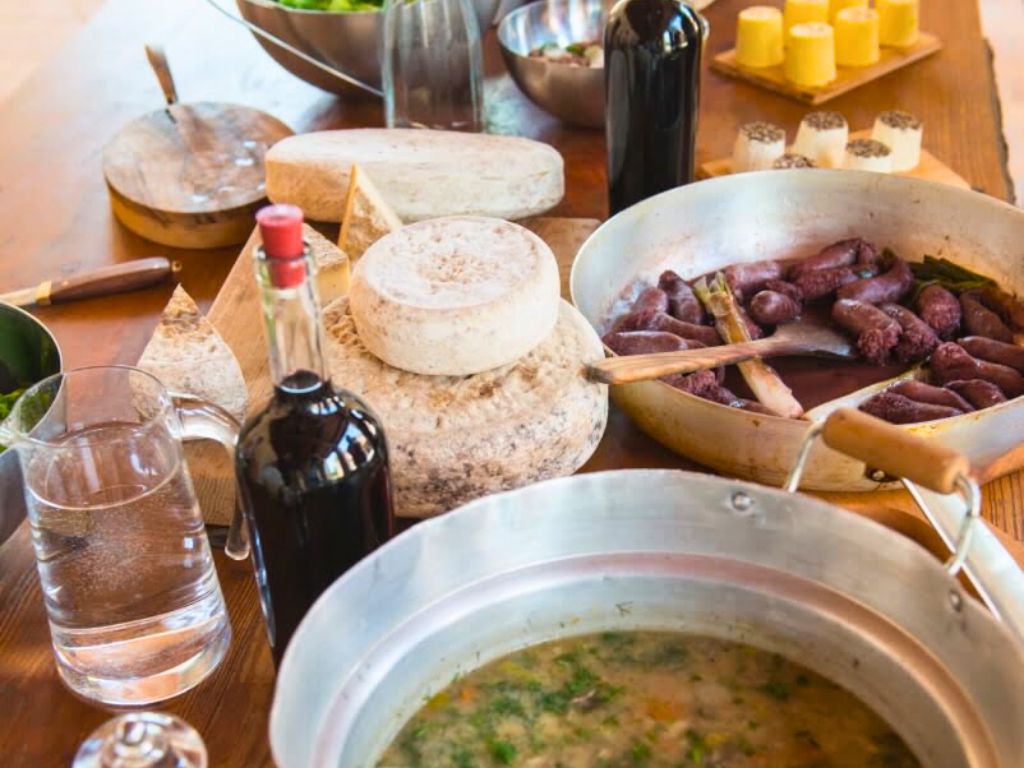 dining table with typical Istria products including soup, sausages, cheeses and wine