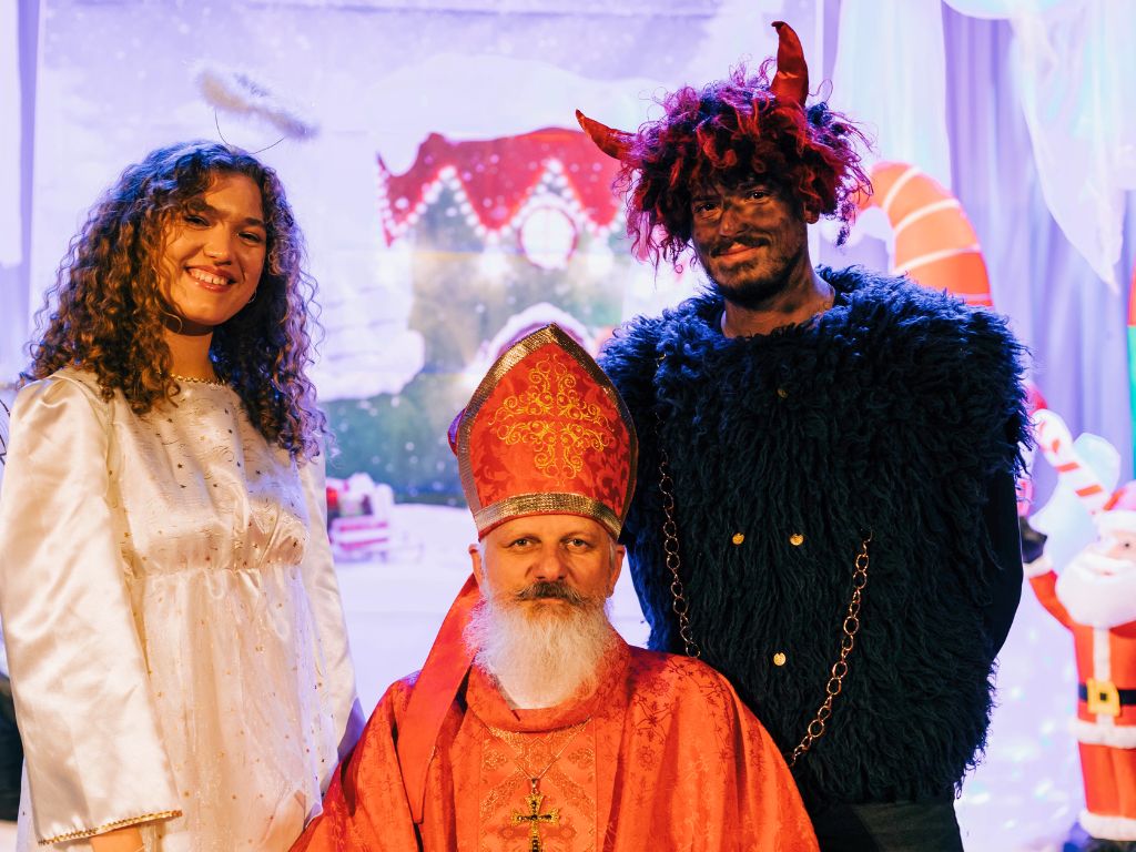 people dressed up as saint nicholas, an angel and a demon for december 5