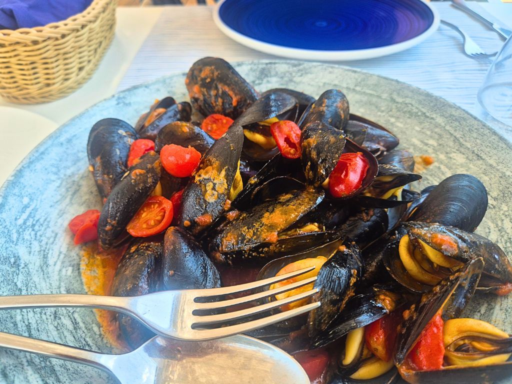 eating and drinking in campania with a large bowl of mussels in a tomato sauce